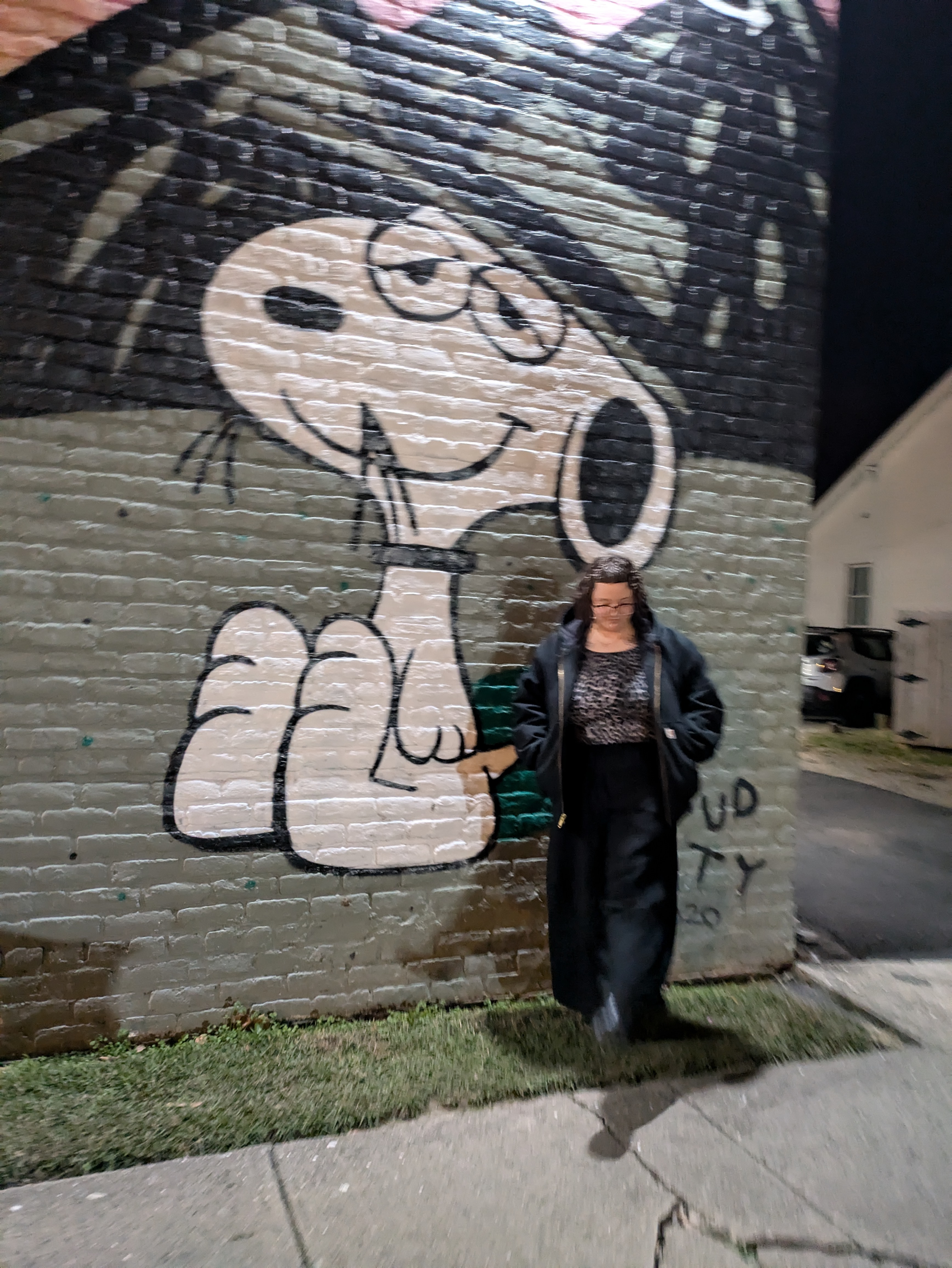 k next to a mural of snoopy's brother spike